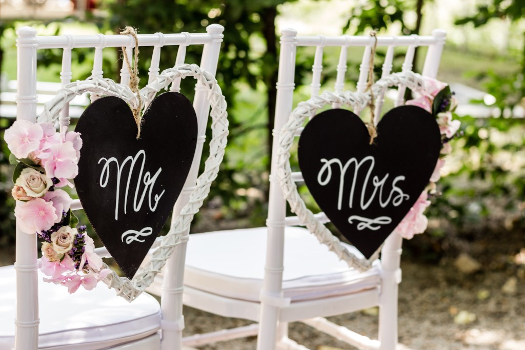 weiße Chiavari Hochzeitsstühle mit Blumendeko