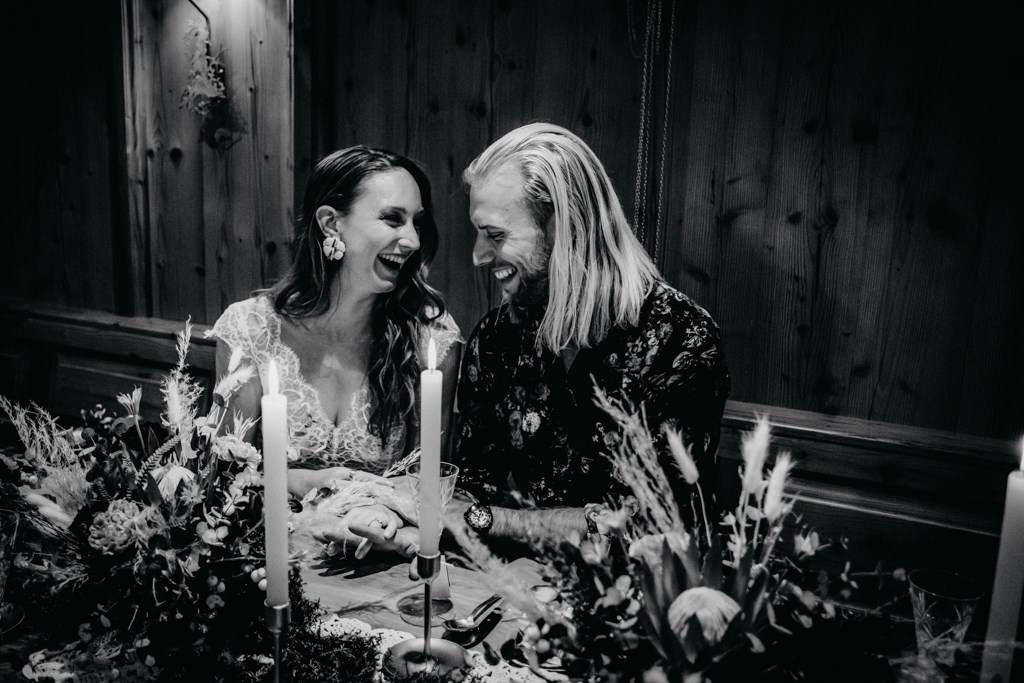 Brautpaar sitzend an dekorierter Hochzeitstafel