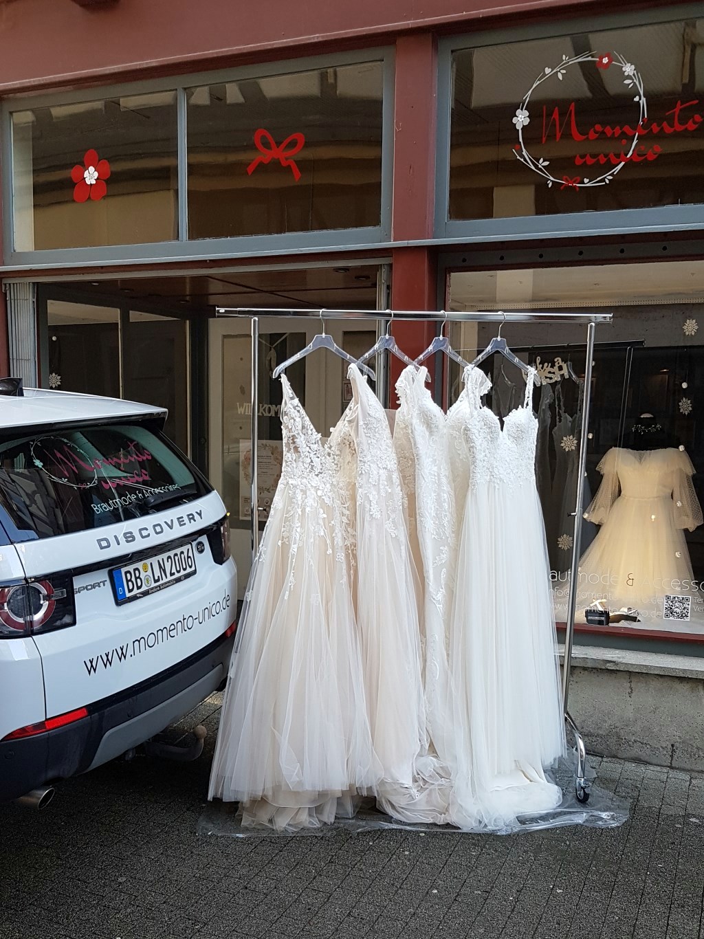 Brautkleider auf Ständer mit Brautmobil